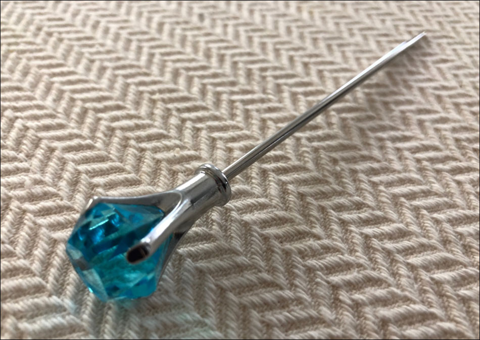 A cocktail pick with a gemstone head