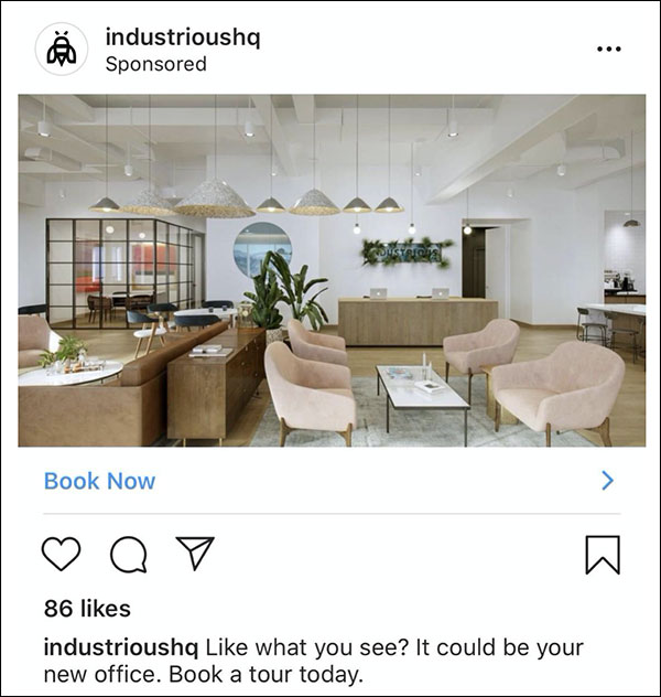 IndustriousHQ's Instagram ad with a photo of one of their modern offices with white walls and light wood accents with caption, "Like what you see? It could be your new office. Book a tour today.