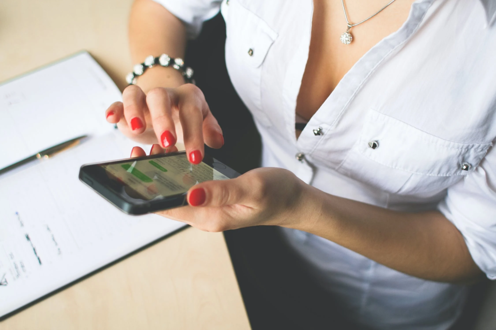 A woman reading her texts on an iphone.